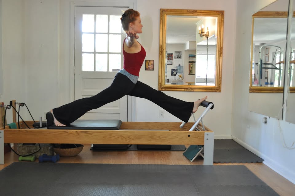 Ashley mid-stretch on a reformer in the studio