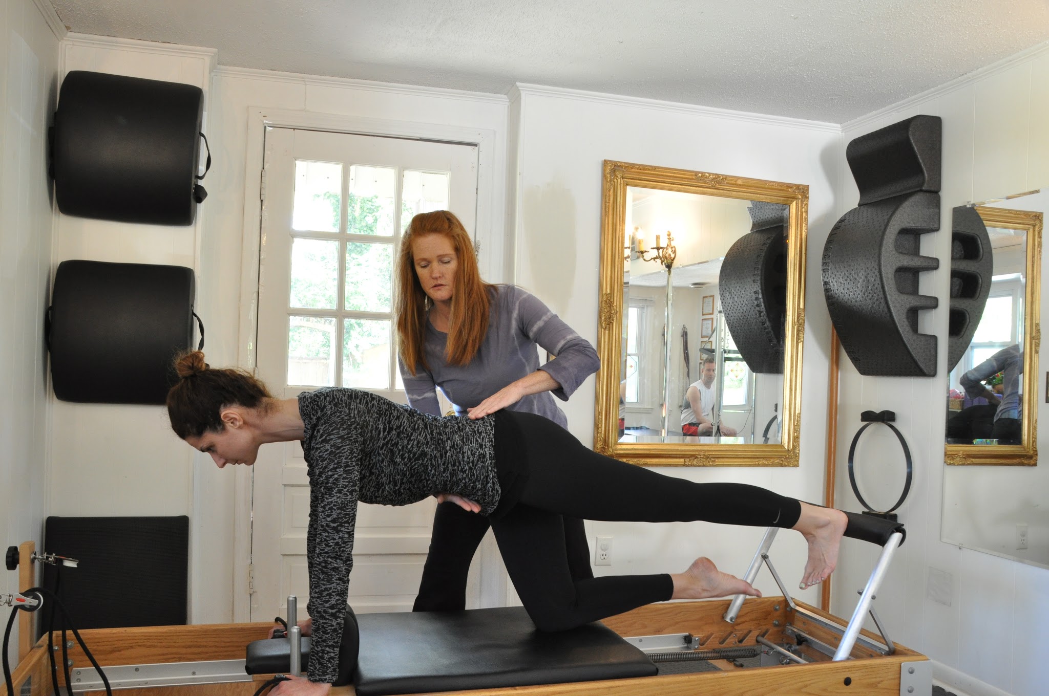 A client working on a reformer while I coach her position